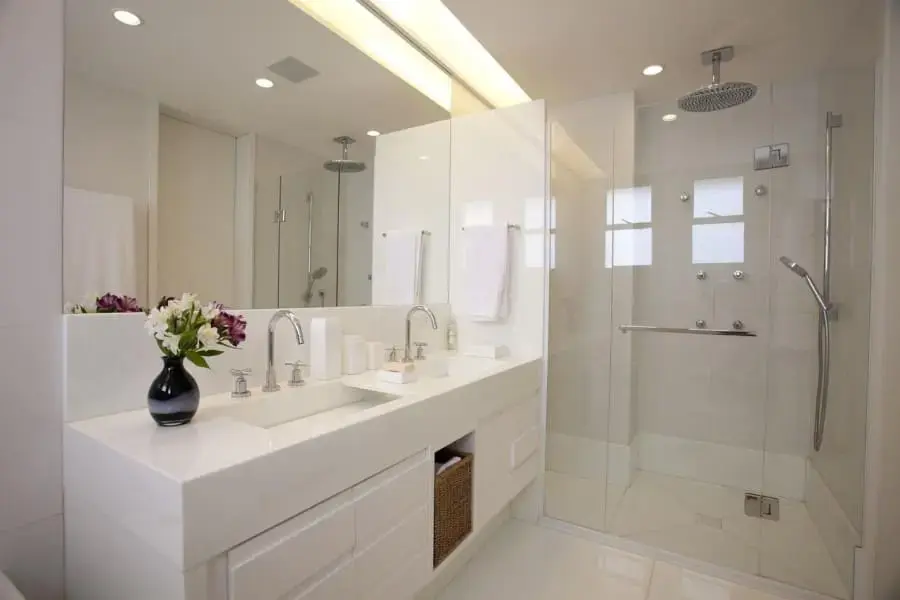 Banheiro de casal com móvel planejado na cor branca e luminária embutida (foto: Ila Rosete)