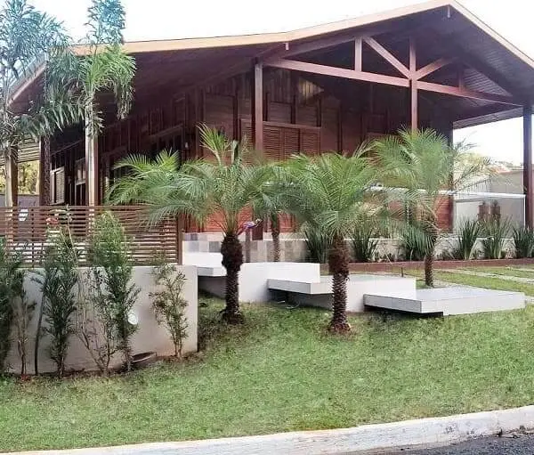 Projeto de Casa de Praia: casa de madeira com pequenas árvores (fonte: @boncasaoficial)
