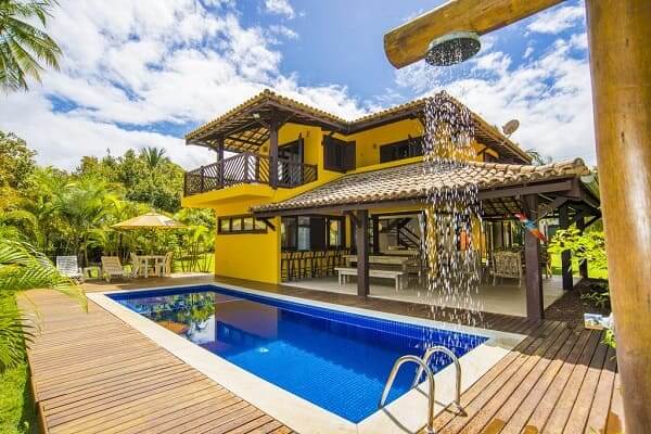 Projeto de Casa de Praia: fachada amarela combina com clima do litoral (fonte: Booking)