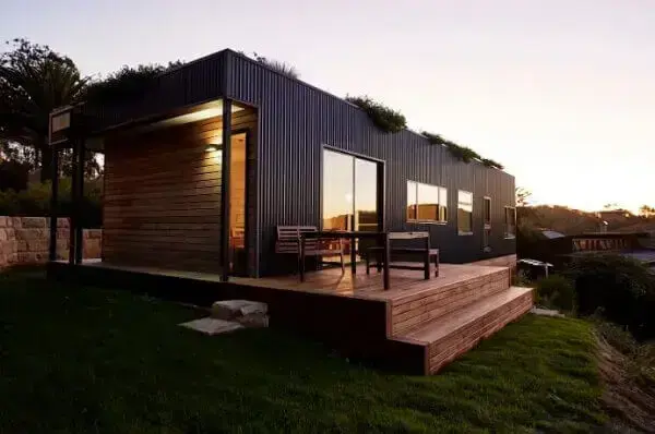 casa de hogar sostenible con grandes ventanales y techo verde Australia