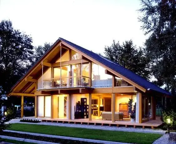 Fachadas de casas térreas com telhado de duas águas: chalé de madeira com fachada de vidro tem integração com a natureza