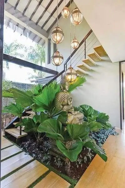 Jardim embaixo da escada: estátua de buda e luminárias