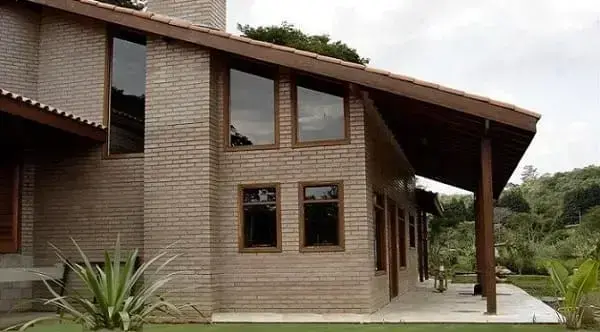 Casa de tijolo ecológico com janelas de madeira (foto: Pinterest)