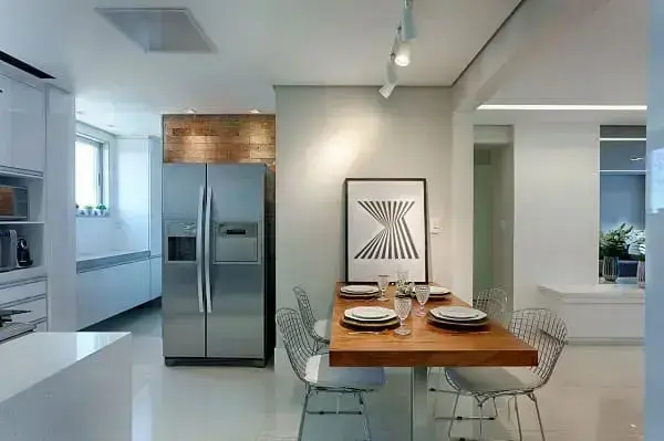 Iluminação de trilho de cozinha sobre a mesa e spot na parede de tijolinho (projeto: Maria Laura Coelho)