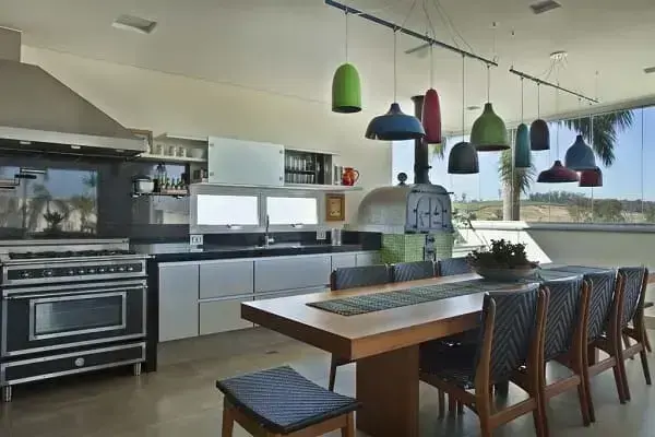 Iluminação de cozinha: pendentes coloridos sobre a mesa (projeto: Guardini Stancati Arquitetura + Designer)