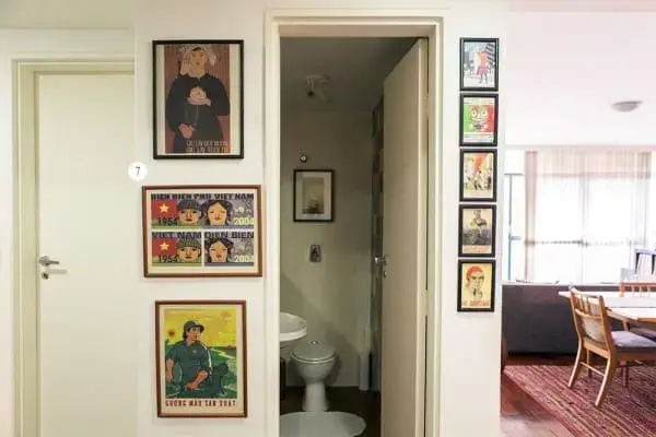 Parede de quadros em entrada de banheiro deixa espaço descontraído (projeto: Casa Aberta)