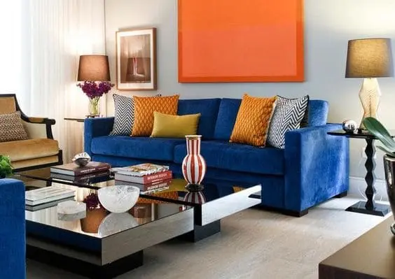 Cores complementares: sofá azul e quadro laranja (projeto: Maria Eunice Fernandes)