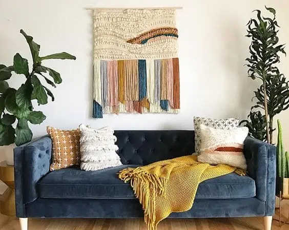 Tapeçaria colorida atrás de sofá azul (projeto: Pinterest)
