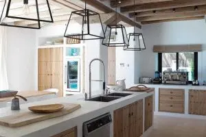 Cozinha de alvenaria com portas de madeira e luminárias pretas foto casa de valentina