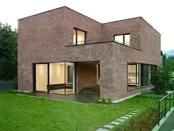 Casa de tijolo ecológico com esquadrias pretas e linhas retas (Foto: Olaria Ecológica)