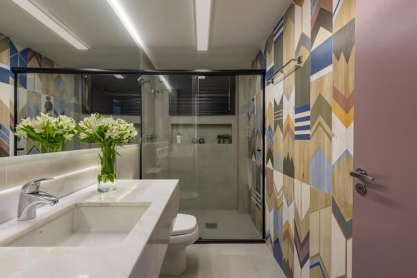 Nicho de porcelanato de cor neutra em banheiro com papel de parede colorido (projeto: MIS Arquitetura e Interiores)