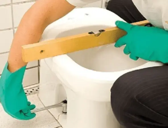 Como instalar vaso sanitário: parafusando a bacia no piso (foto: Pinterest)