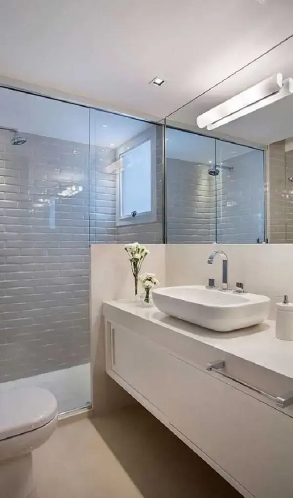 A luminária de espelho de banheiro é discreta e auxilia na decoração do espaço