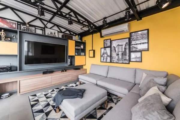 Estilos de casas: sala de estar contemporânea com parede amarela e sofá cinza (projeto: Pietro Terlizzi)