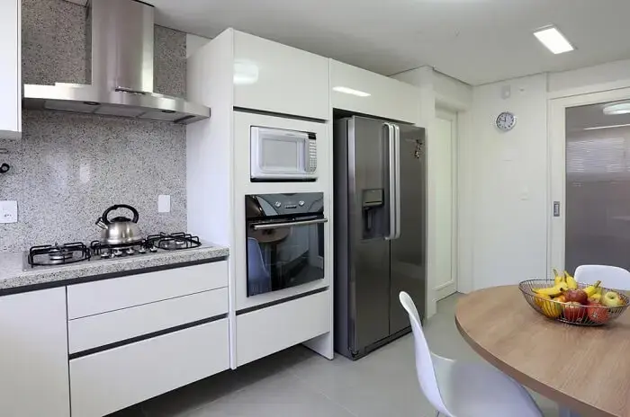 Estilos de cozinhas planejadas: o armário de cozinha estilo planejado conta normalmente com nichos para microondas, fogão, forno e geladeira. Projeto de Fernanda Renner