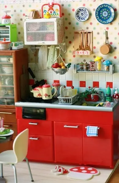 Kitsch: cozinha com gabinete vermelho e decoração colorida na parede (foto: Pinterest) 