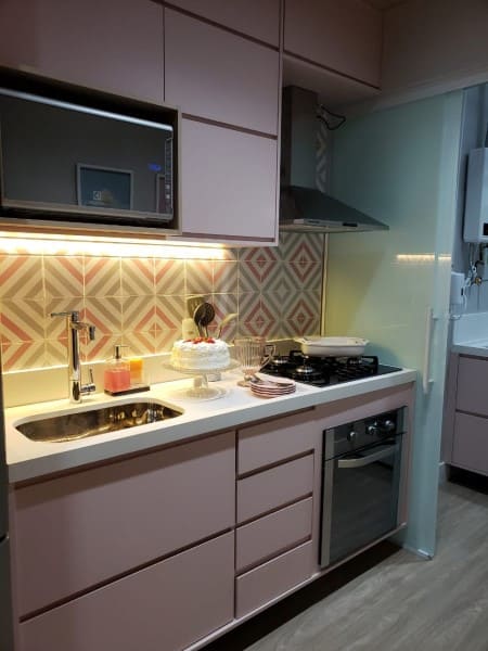 7. Cozinha linear planejada com marcenaria rosa e porta de correr de vidro (foto: Giovana Ciacco Interiores)
