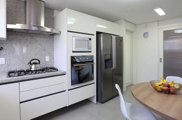 Cozinha linear com torre quente ao lado da geladeira (foto: Fernanda Renner)