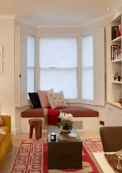 Bay Window com moldura branca e almofadas coloridas (foto: Decor Fácil)