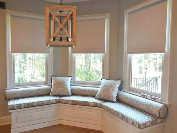 Bay Window sofá branco e pendente de madeira criam composição aconchegante (foto: @ladydianneswindowtreatments)