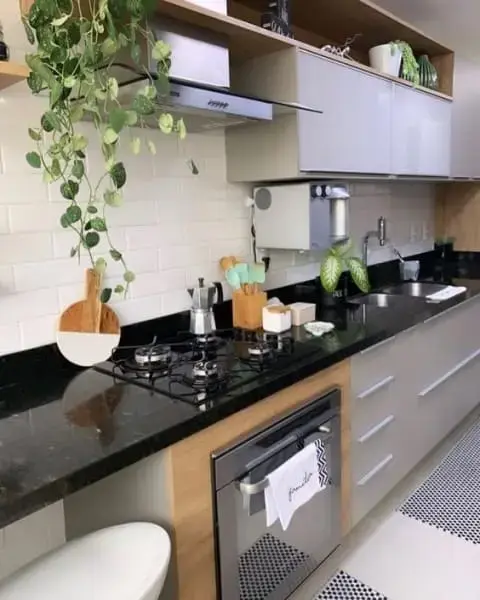 Granito Preto São Gabriel: bancada de cozinha com cooktop e plantas (foto: Tua Casa)