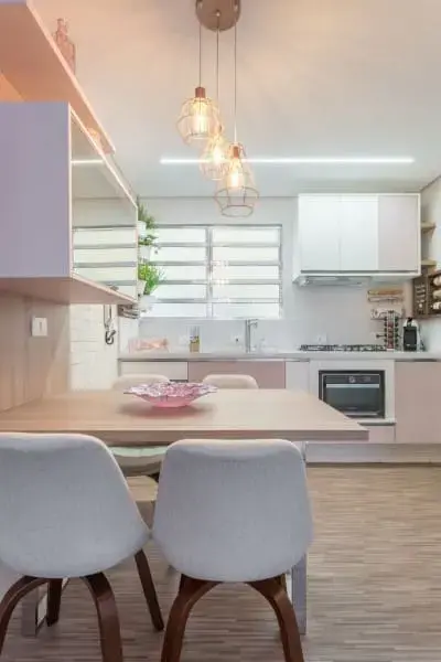 Perfil de LED em cozinha com pendentes e cadeira rosa (foto: Márcia Addor)