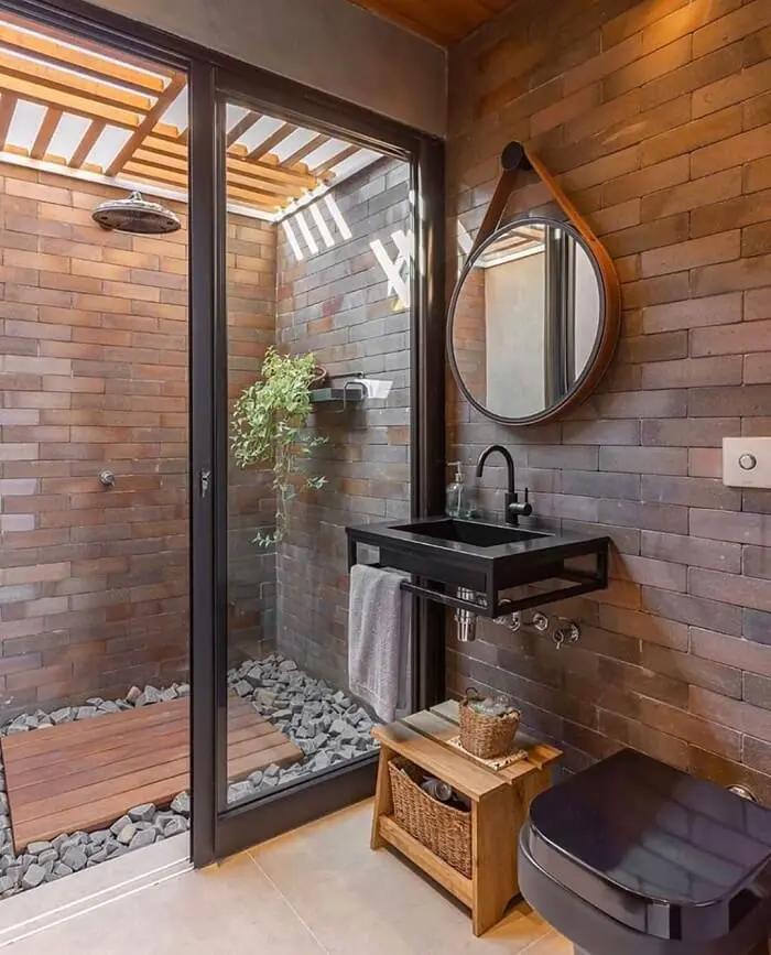 Banheiro externo onde a área do banho é cobertura por um pergolado de madeira. Fonte: Priscila Valente Arquitetura