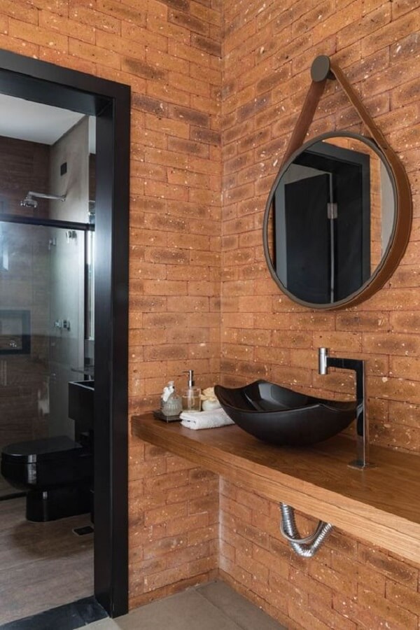 Banheiro externo pequeno com parede revestida de tijolinhos aparentes. Fonte: Casa Vogue