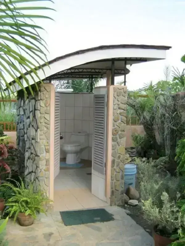 Banheiro externo simples com cobertura que facilita a ventilação do ambiente. Fonte: Roomble