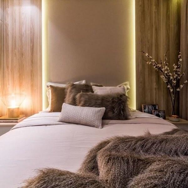 Quarto com luz de led: a parede da cabeceira da cama ganhou destaque com a iluminação de LED. Fonte: Larissa Rabelo Interiores