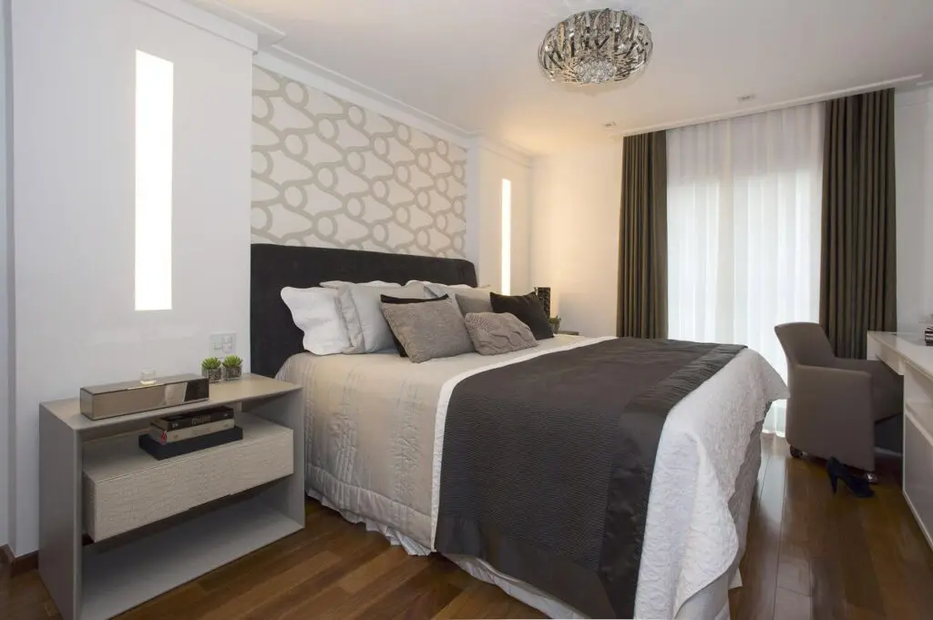 Rodateto branco e papel de parede estampado trazem um toque moderno ao quarto de casal. Fonte: Érica Salguero