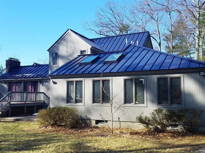 A tinta para telhado azul se destaca na arquitetura da casa de campo. Fonte: Classic Metal Roof
