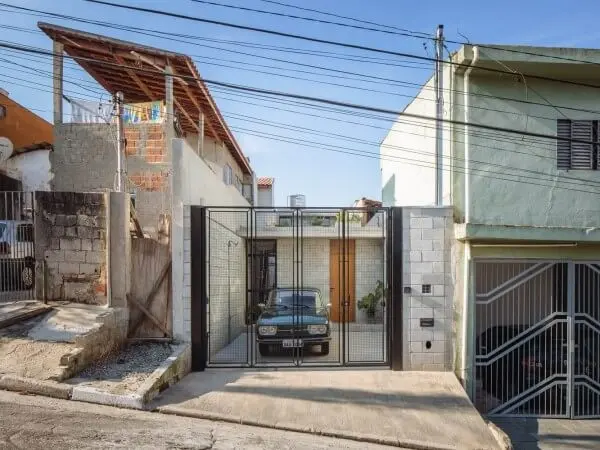 Casa de concreto com portão de ferro (projeto: Terra e Tuma Arquitetos /foto: Pedro Kok)