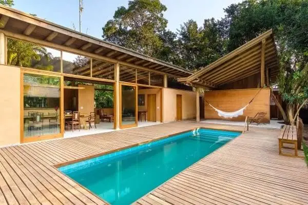Taipa de pilão casa com piscina com sala integrada com área externa (Casa AA - Argus Caruso - arquitetura e construção Foto Gustavo Uemura)