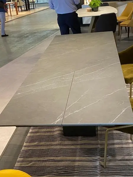 Feira de Milão 2022 mesa de jantar com tampo de pedra acinzentada foto Cris Paola
