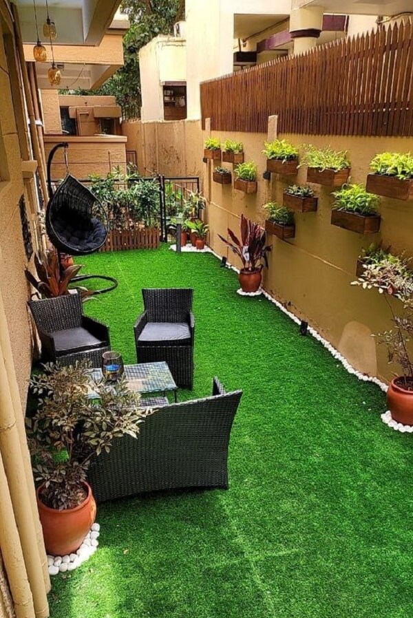 Crie um espaço aconchegante na área externa com moveis de jardim e grama sintética