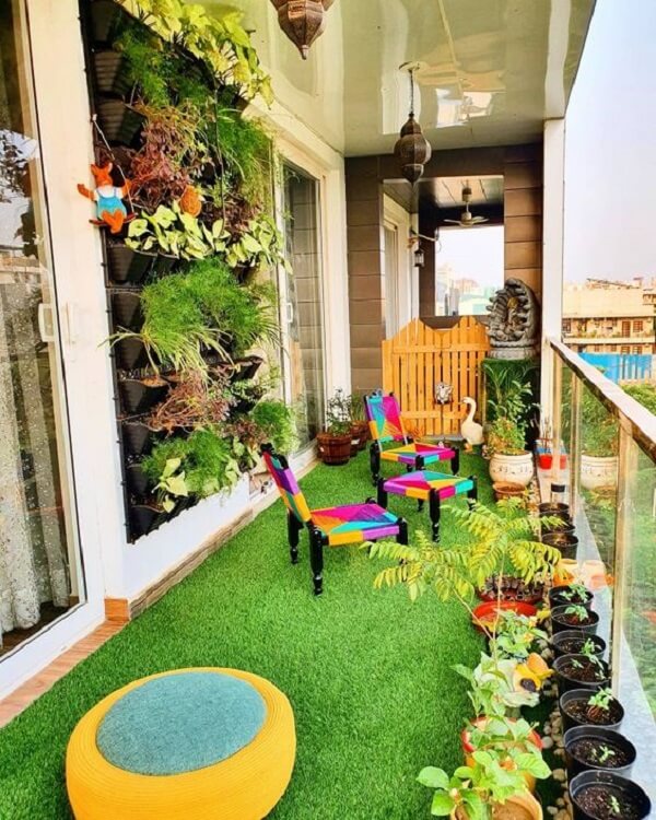 Jardim vertical, vasos de plantas e grama sintética decoram a varanda