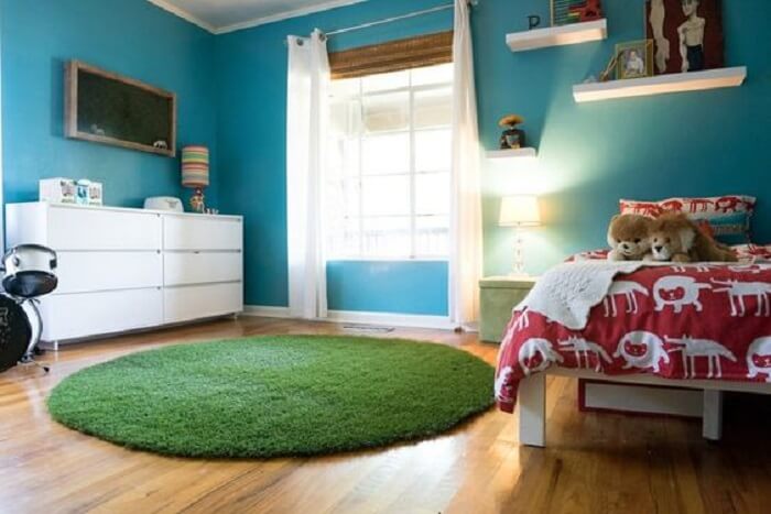 O tapete redondo de grama sintética decora o quarto infantil