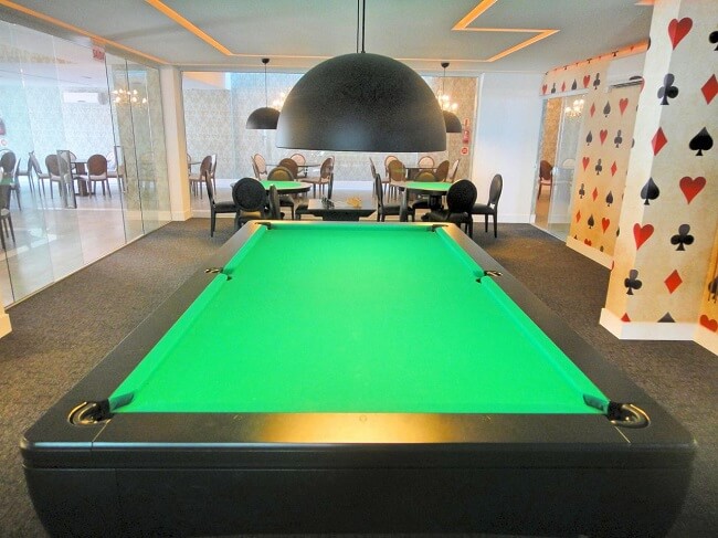 Mesa de sinuca preta com tampo verde para sala de jogos