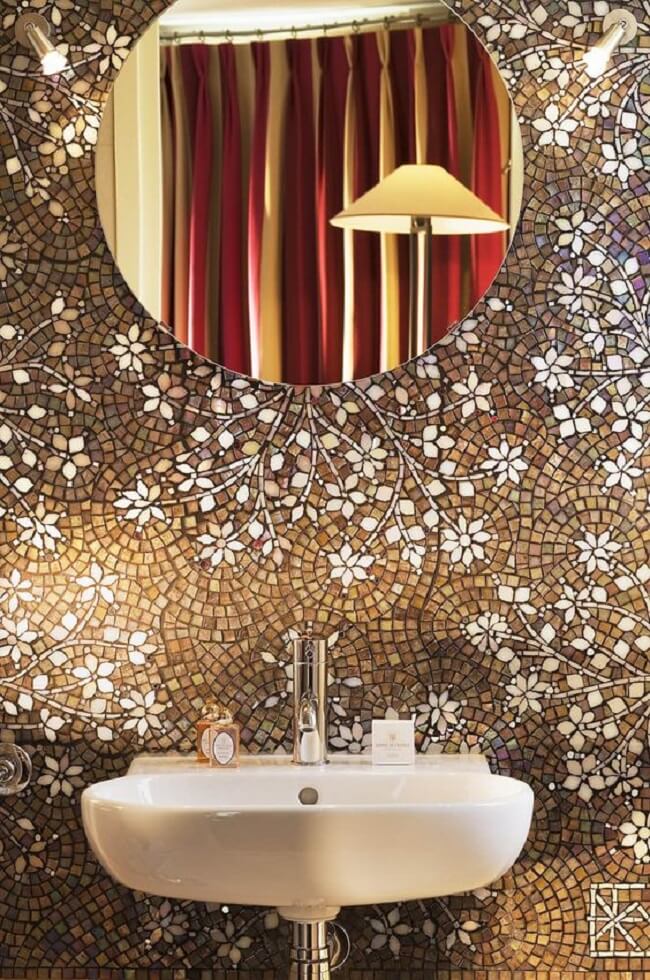 Banheiro com espelho redondo e mosaico na parede do quarto com pastilha de vidro