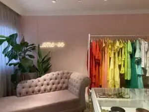 Espaços instagramáveis sofá rosa e letreiro neon em loja foto Mora estúdio